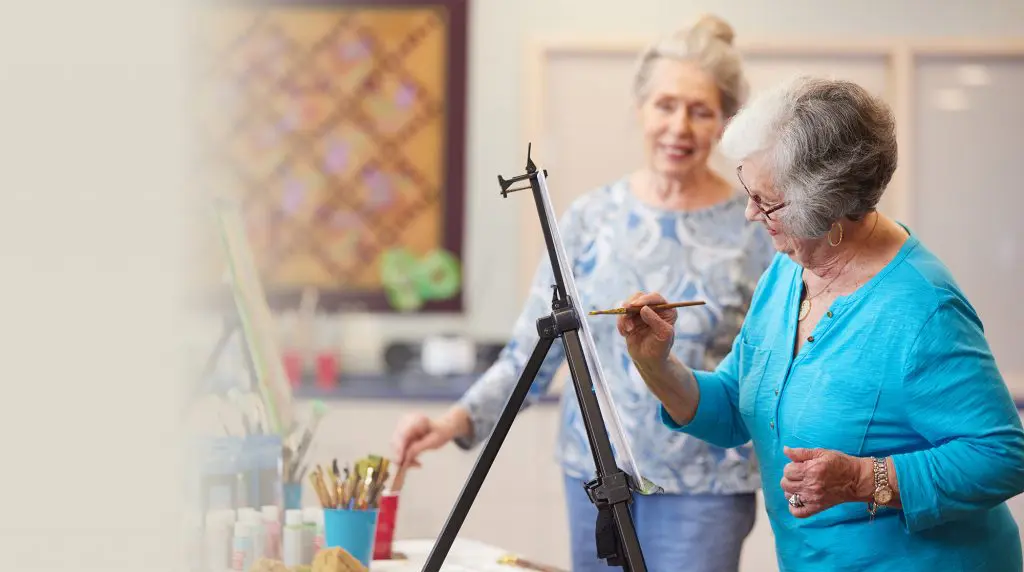 Two elderly women painting as a residents new year's resolution to explore new hobbies at Sedgebrook.