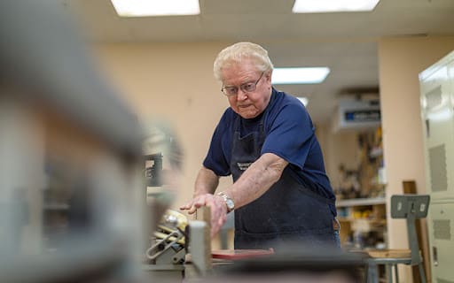 senior man in the woodworking shop at Sedgebrook
