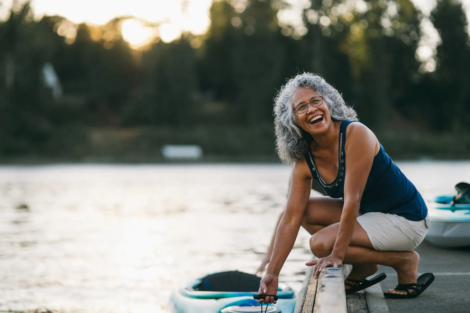 A senior woman pulling in her kayak on a summer day