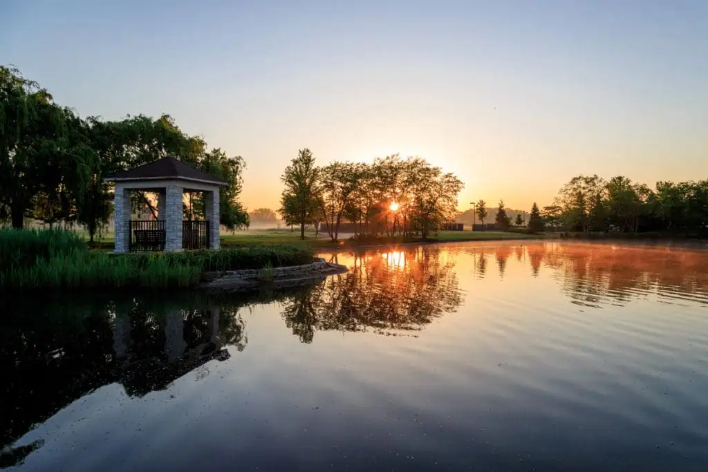 A lake featuring a gazebo at sunset in Sedgebrook in Lincolnshire, IL.