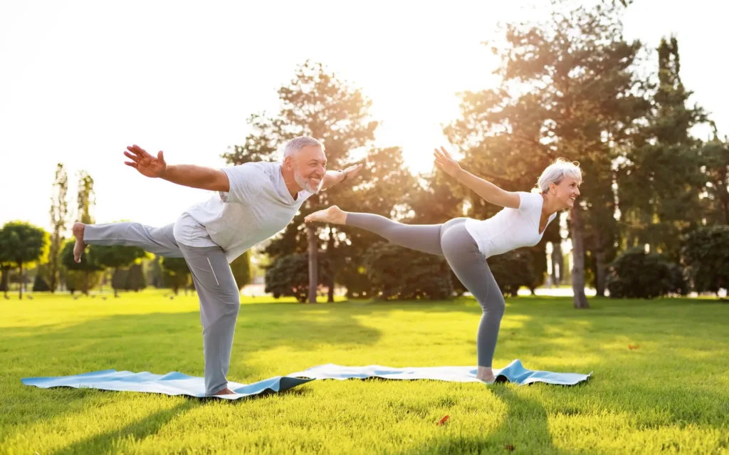 seniors practice yoga in a field