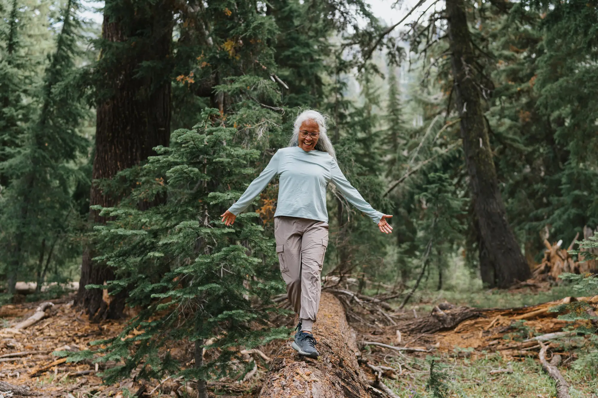 An elderly woman balancing on a tree, while exploring the best blaance exercises for seniors near Sedgebrook in Lincolnshire, IL.