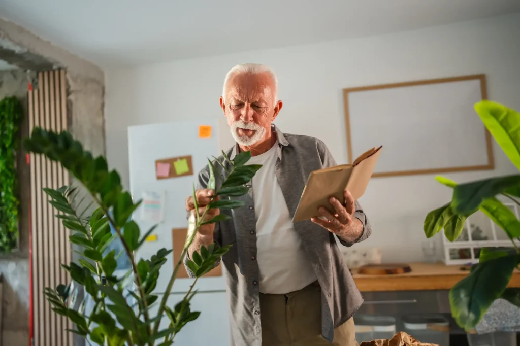 senior man learns how to care for his large plant, one of the many ways of lifelong learning for seniors at Sedgebrook in lincolnshire, IL.