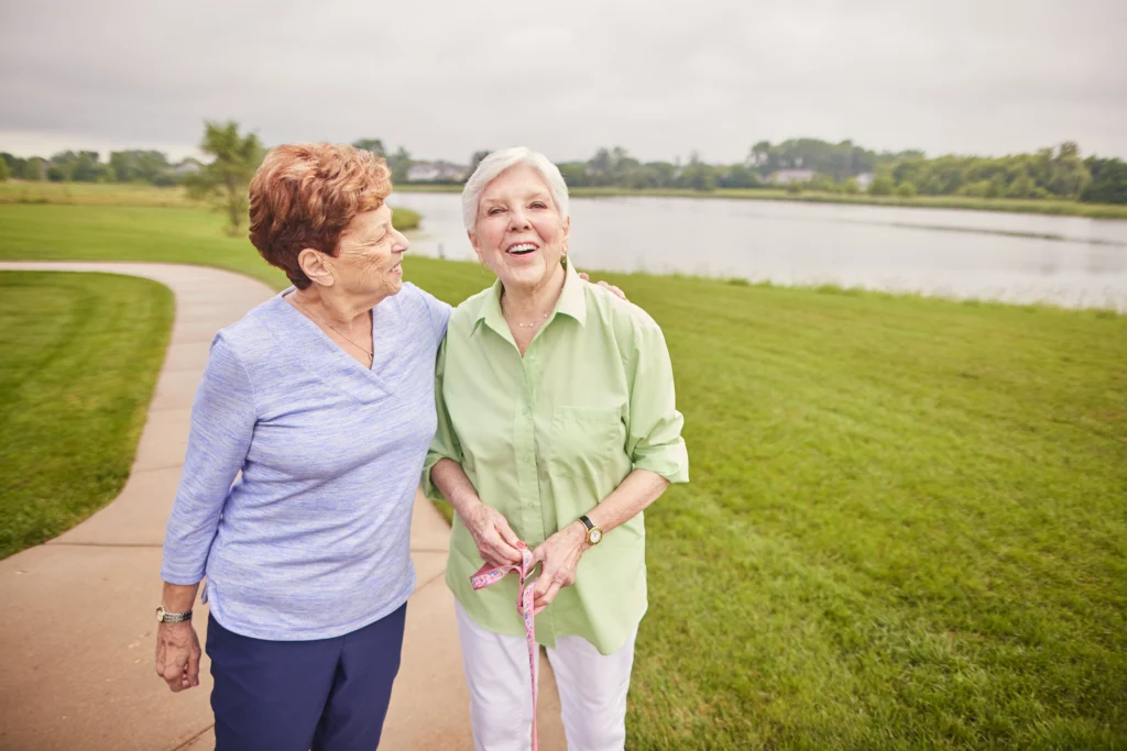 two residents of Sedgebrook walking outside, one of the best springtime activities for seniors in Lincolnshire, IL.