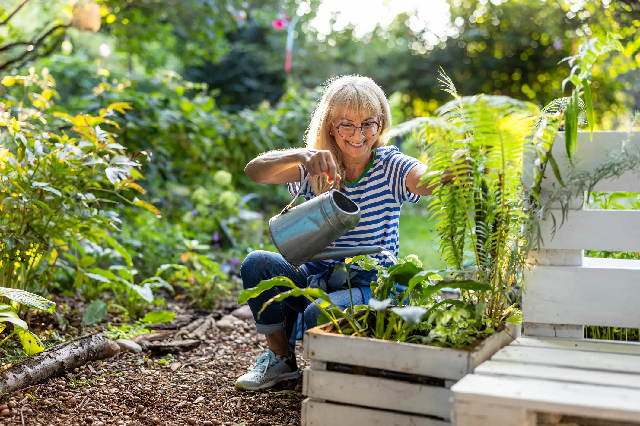 Senior woman watering plants in the garden